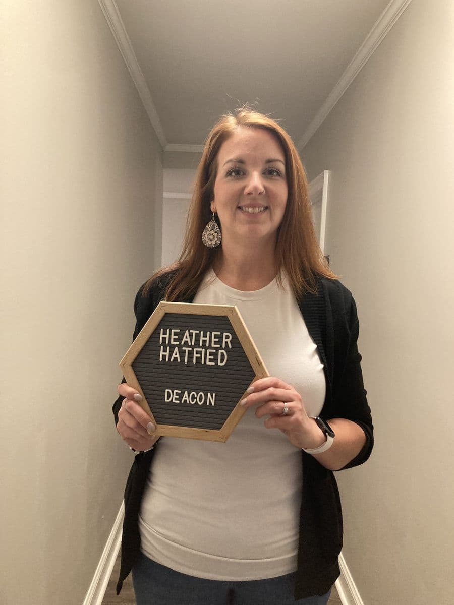 Heather Hatfield holding a letterboard reading Heather Hatfield, Deacon
