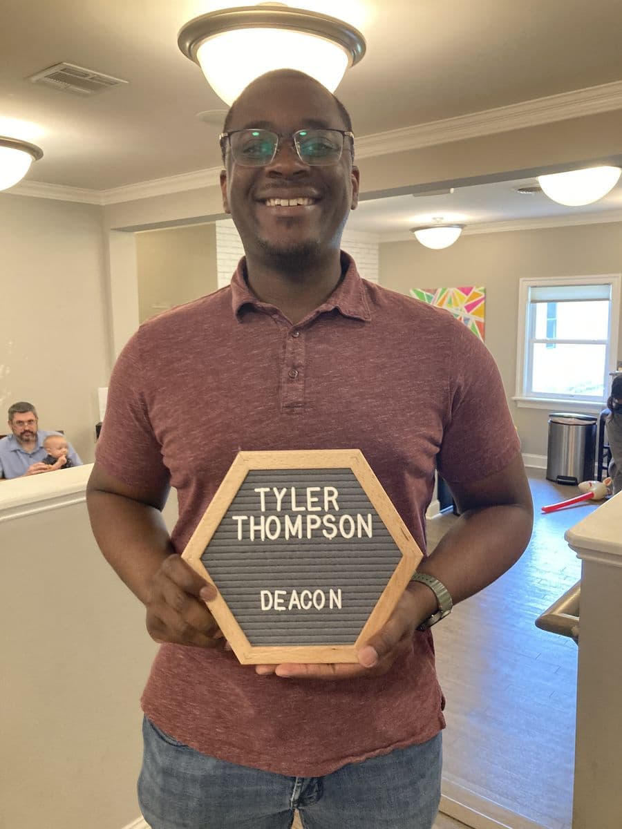 Tyler Thompson holding a letterboard reading Tyler Thompson, Deacon